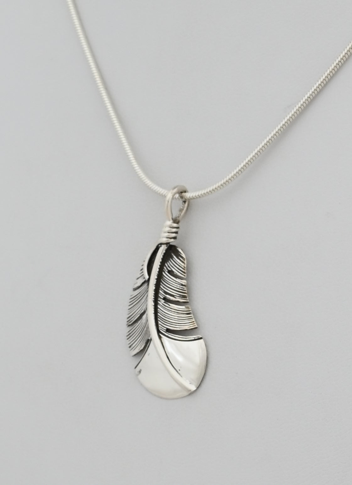 Pendant with Small Curved Feather by Raymond Coriz